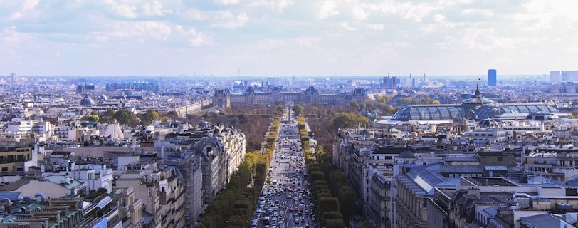 aerial photo of city under white clouds