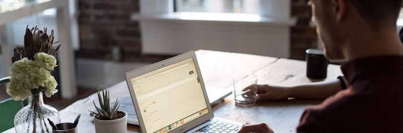 man operating laptop on top of table