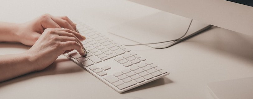 person typing on Apple keyboard