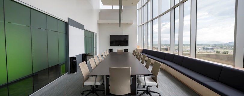 rectangular brown wooden table with chair lot inside building