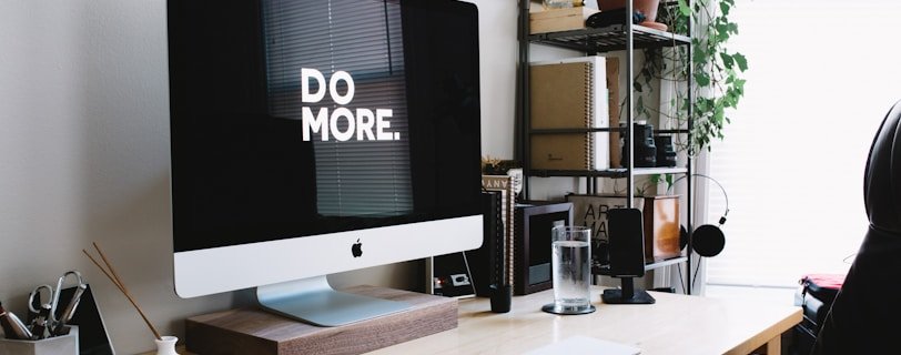 silver iMac with keyboard and trackpad inside room