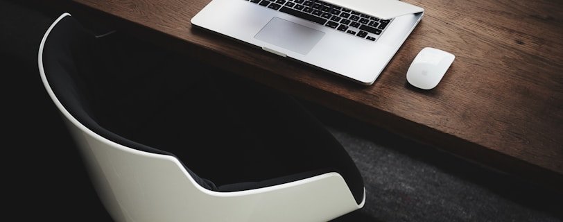 Apple MacBook beside computer mouse on table