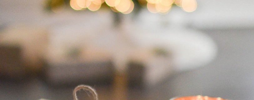 brown gift box beside stainless steel votive candle