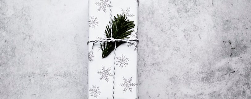 white and black snowflake print gift box on gray surface