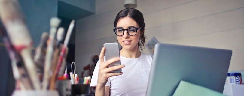 woman in white shirt using smartphone