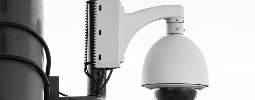 white security camera on post