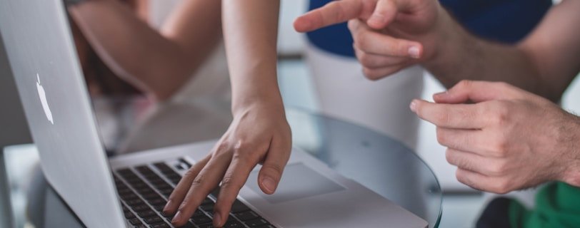 person touching and pointing MacBook Pro