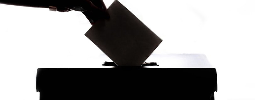 a person is casting a vote into a box