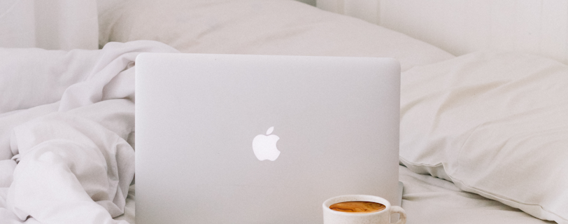MacBook beside teacup with latte