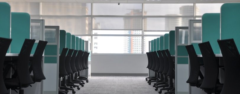 empty black rolling chairs at cubicles