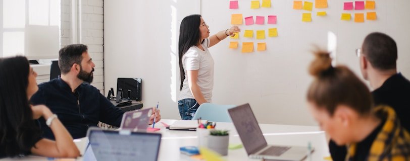 woman placing sticky notes on wall