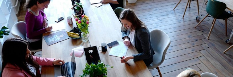 a group of people sitting around a wooden table