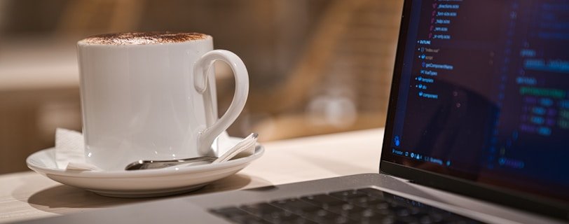 black laptop computer beside white ceramic mug close-up photography
