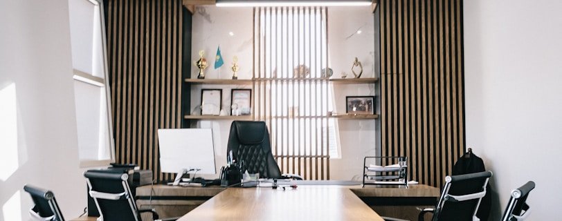 brown and black office table and four black cantilever chairs