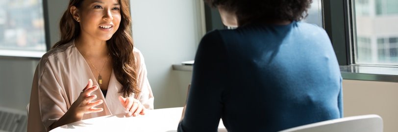 two women sitting on chair