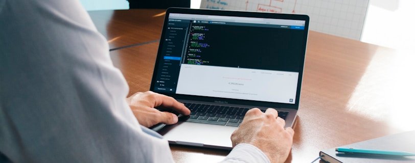 person wearing grey dress shirt beside table