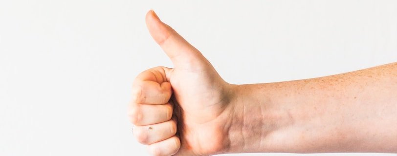 persons right hand doing thumbs up