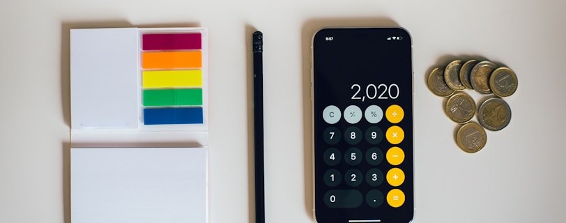 black iphone 4 beside black and silver remote control