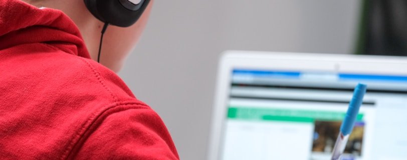 person in red shirt wearing black and gray headphones