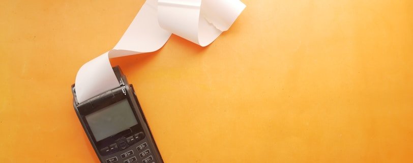 a cell phone sitting on top of a table next to a roll of paper