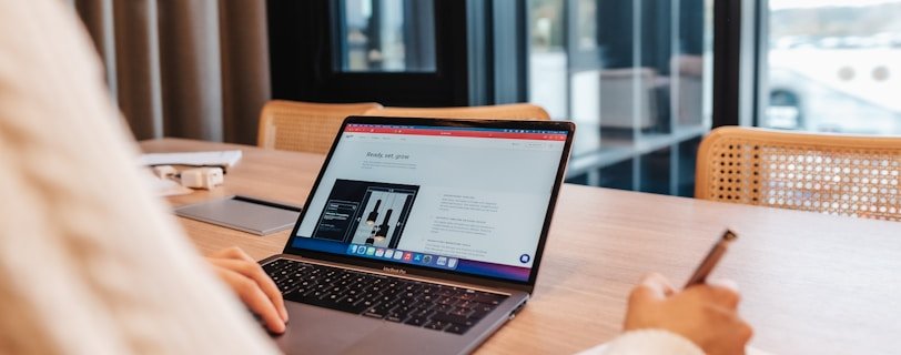 a person sitting at a table with a laptop