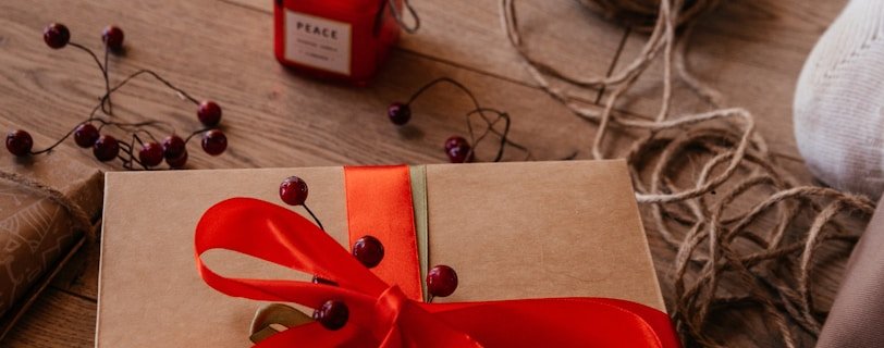 a wrapped present sitting on the floor next to a jar of jam