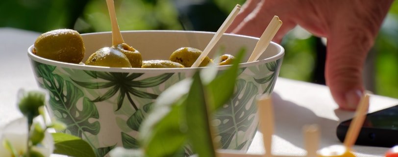a bowl filled with olives and peppers on a table