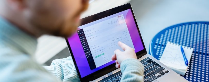 a man sitting at a table using a laptop computer