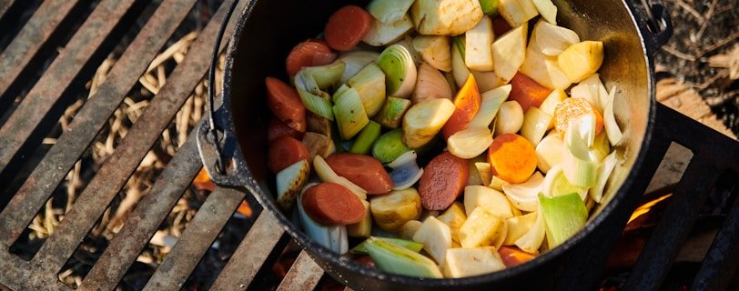 a pot filled with vegetables sitting on top of a grill