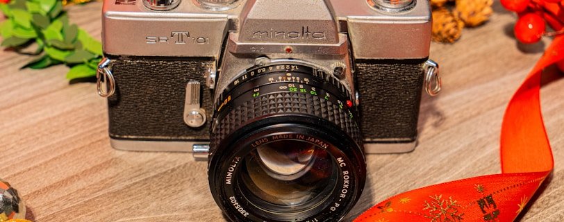 a silver camera sitting on top of a wooden table