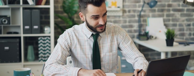 a man sitting at a desk working on a laptop