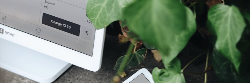 A person holding a credit card next to a computer